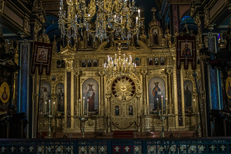 a golden alter, with chandelier above it