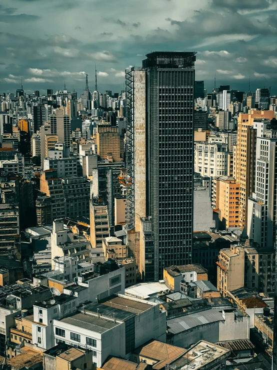 some very tall buildings and gray skies with many clouds