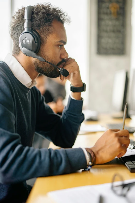 a man sitting at a desk with a headset on