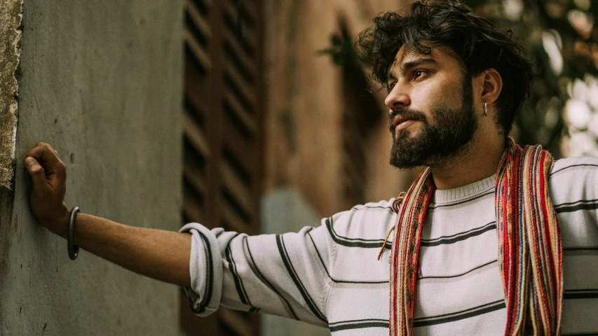 the man is posing for the camera near a wall