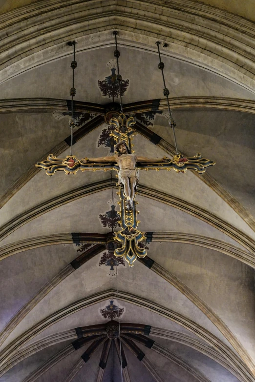 a large metal cross hangs from the ceiling in a church