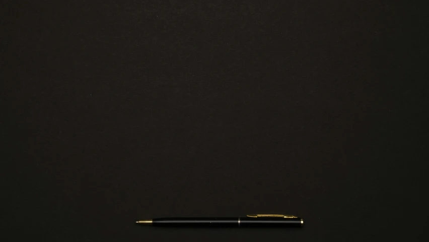 a pen sitting on top of a black background