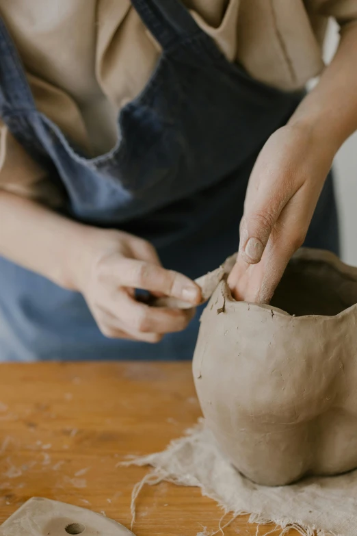 a person that is putting soing in a clay pot