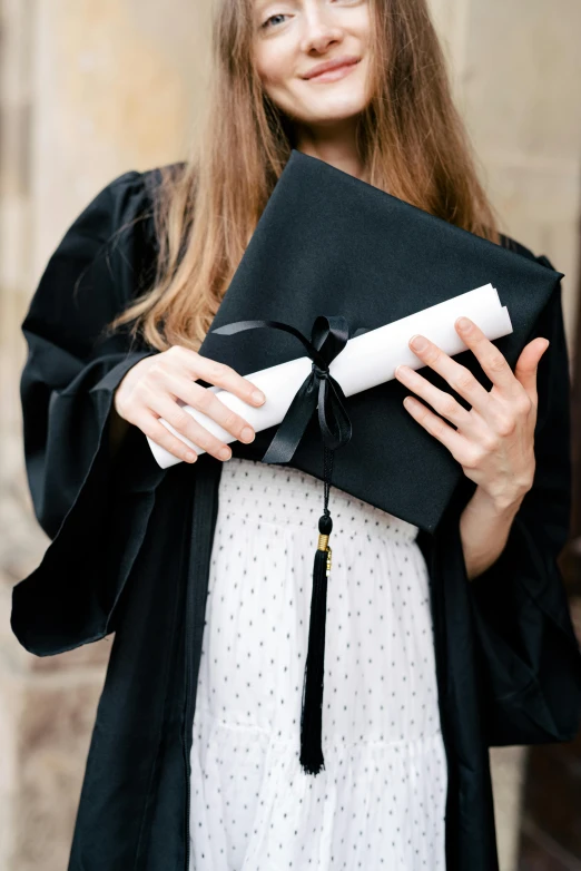 a girl holds her graduation cap and diploma
