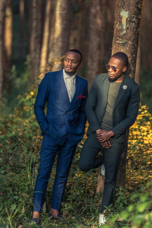 two men in blue suits pose next to each other