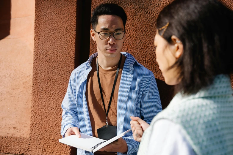 a man in glasses and blue shirt talking to someone