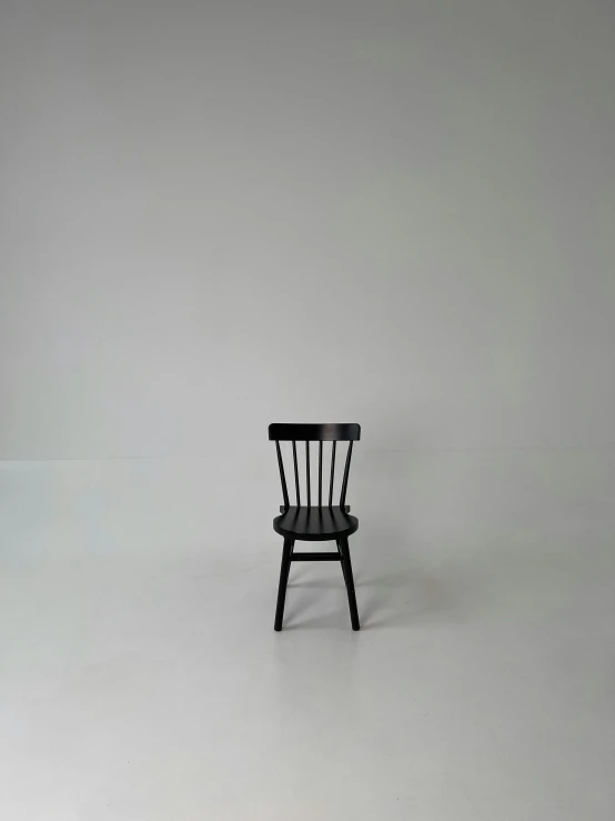 a single black chair in an empty room