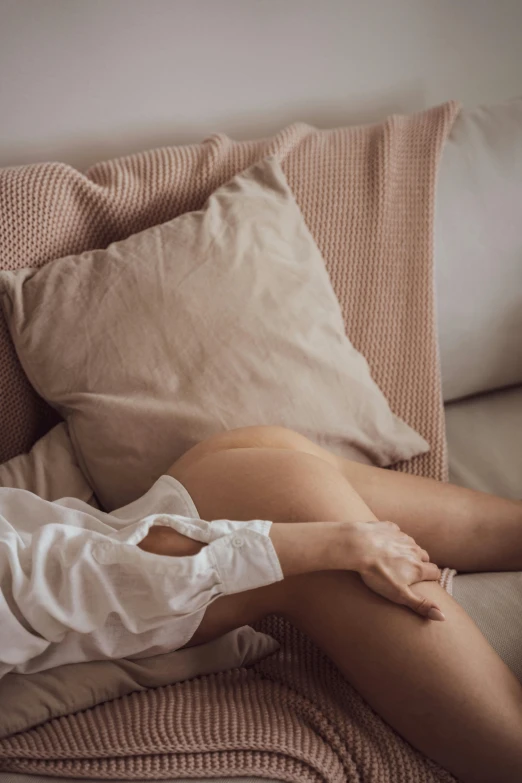 a person sitting on the couch with her hands on their knees