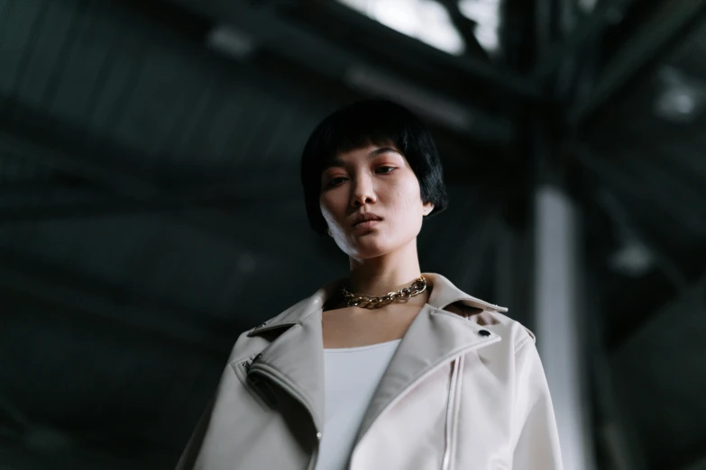 woman wearing white coat and a gold necklace