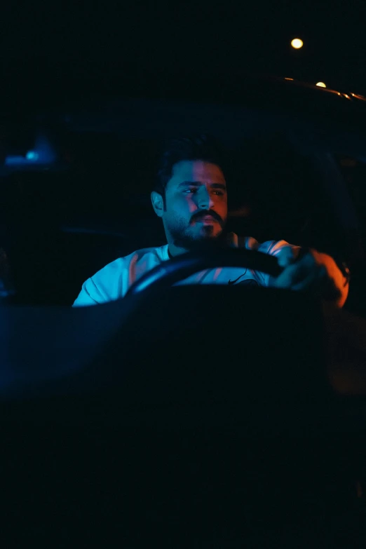 man in the back seat of a car driving through dark