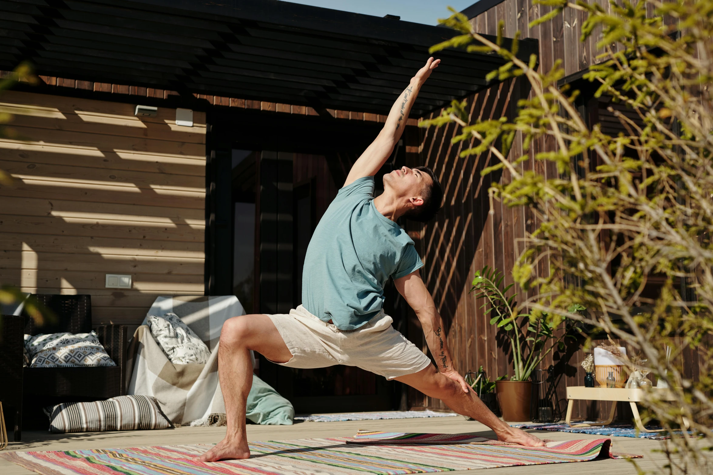 a man is practicing yoga outside on his deck