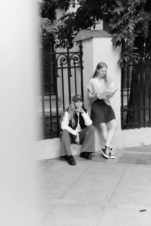 a man and woman sitting on the side of a building