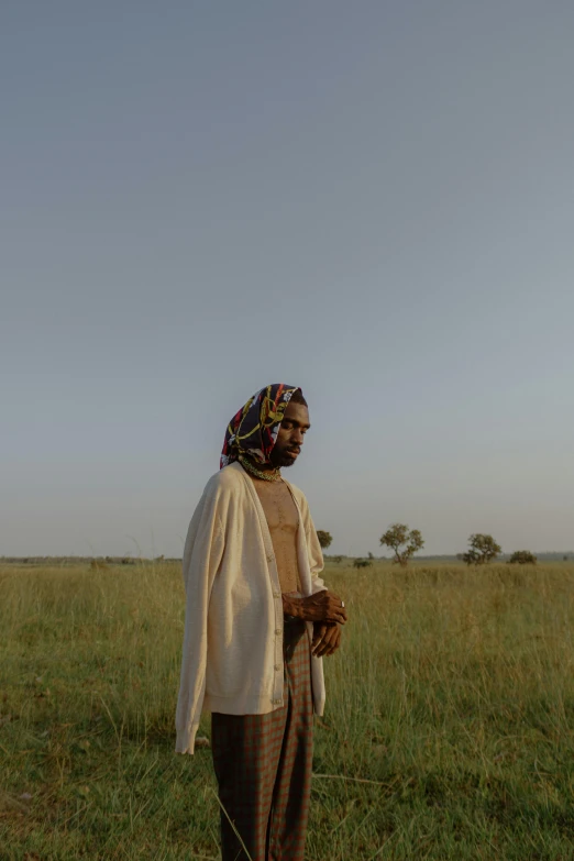 a man standing in a field holding a kite