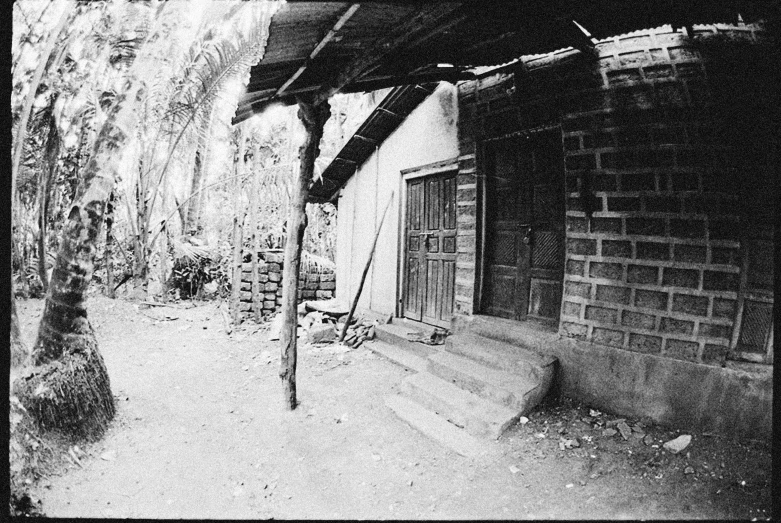 a wooden gate in a stone house near brick pillars