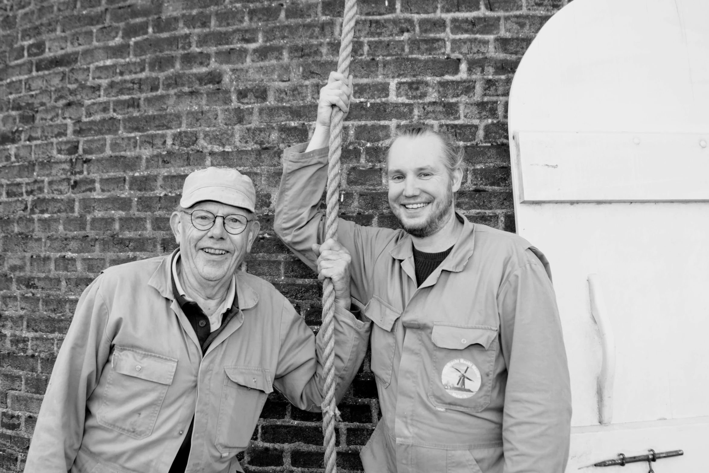 two men holding on to an old wire line