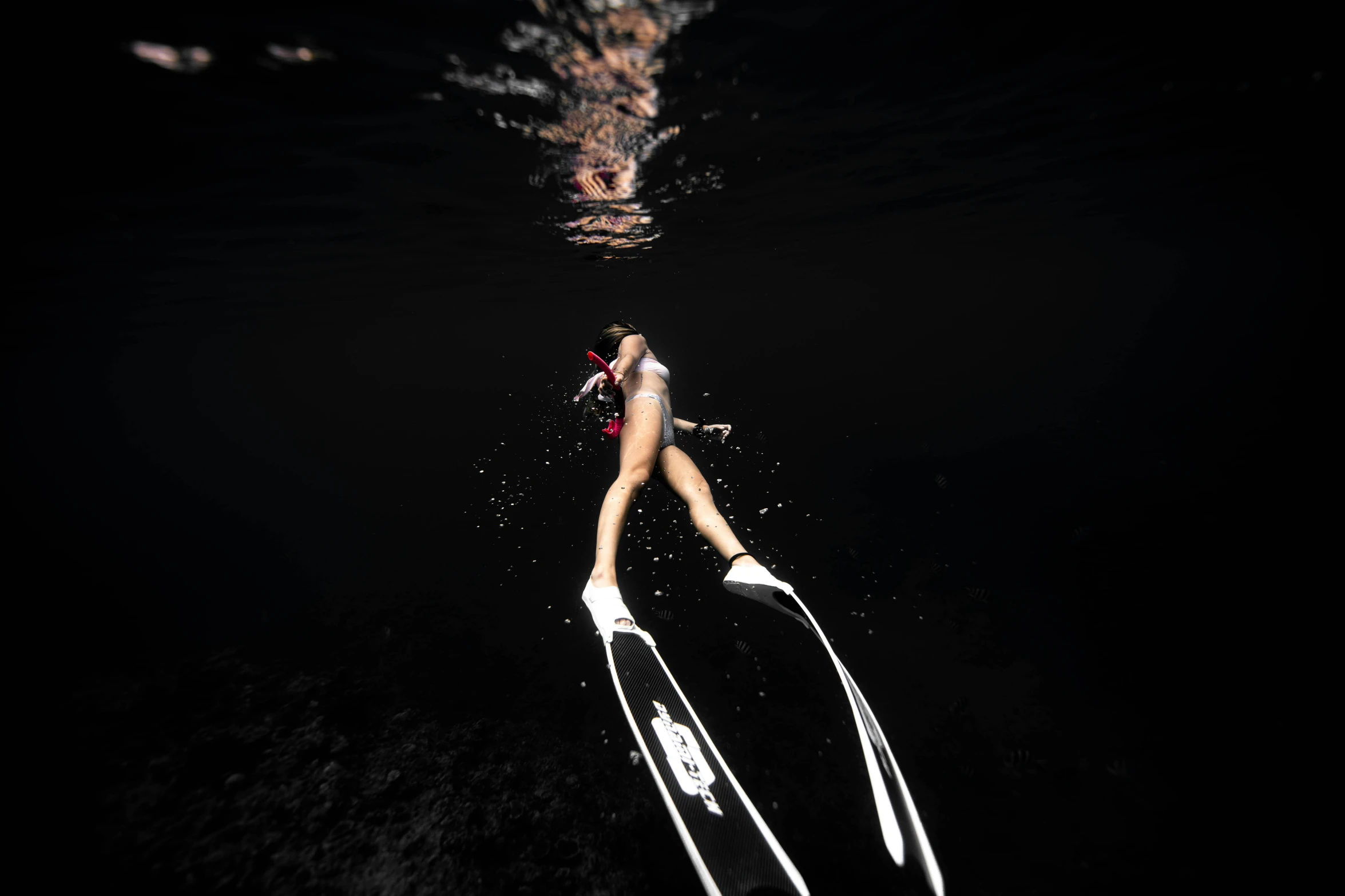 a woman dives into the water from the surfboard