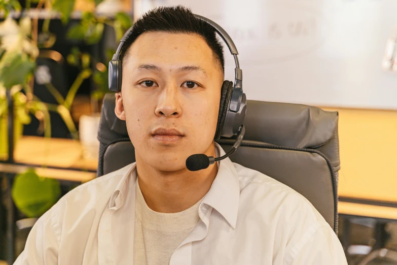 a man wearing a headset sits in a chair