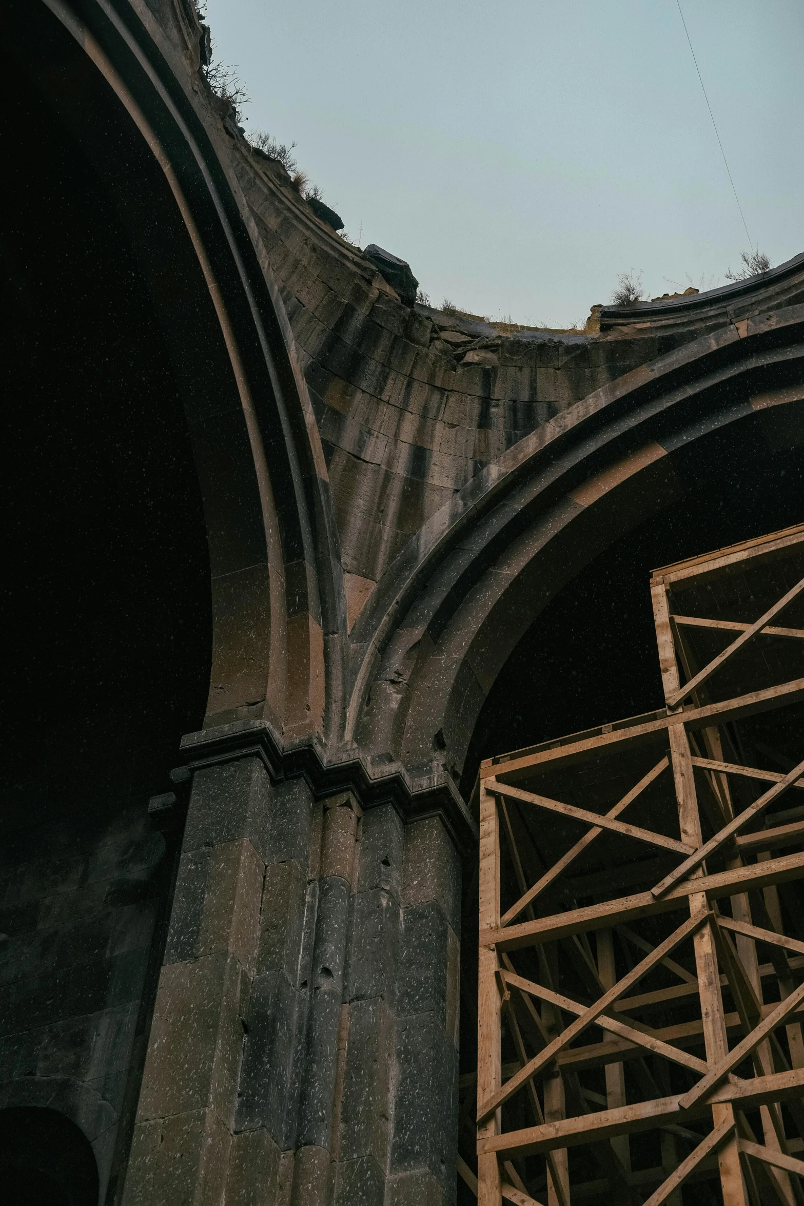 some type of structure with wood and a sky in background