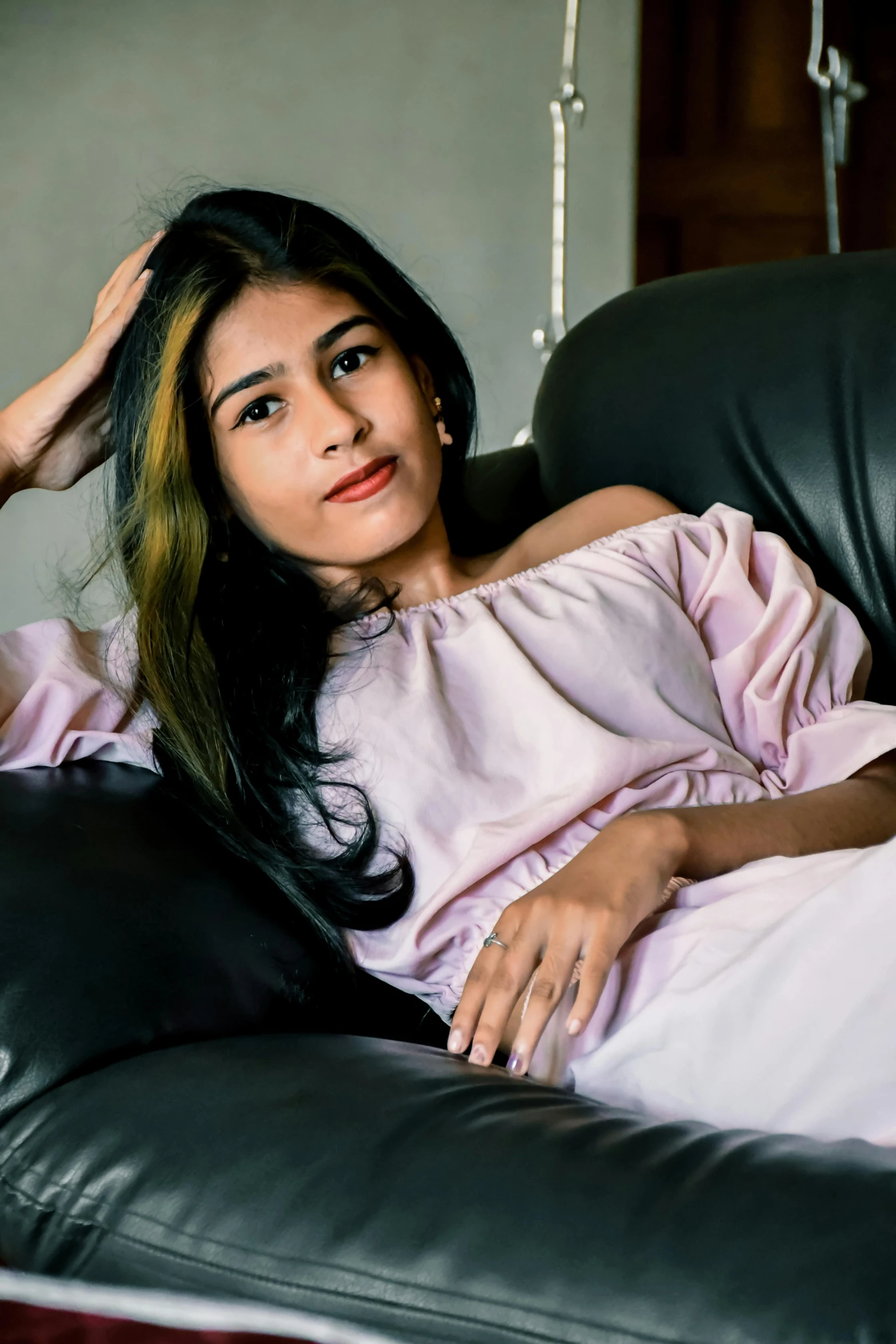 young woman in pink dress resting on a chair