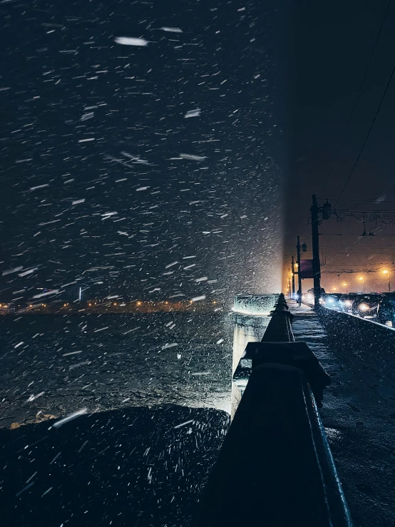 night scene with snow falling on the street and power lines