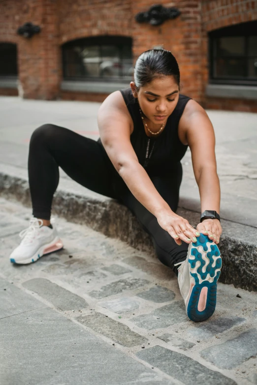 a woman is stretching while she sits on the ground