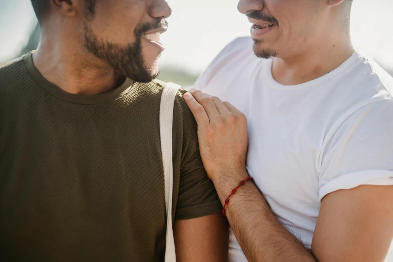 a man holds his shoulder as another looks on