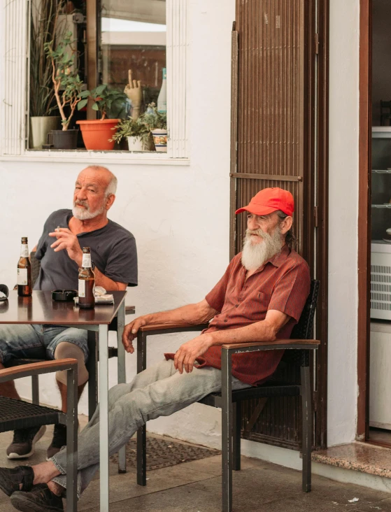 two men sit down with beers near them