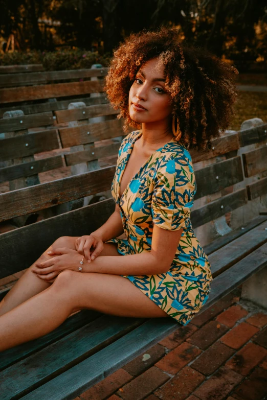 a woman is sitting on a bench in the middle of the park