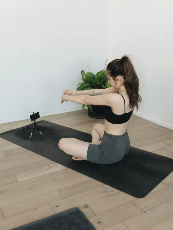 a young woman practices yoga in her living room