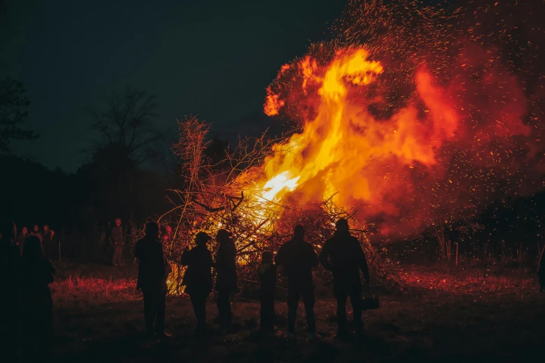 some people standing in front of a lit up fire