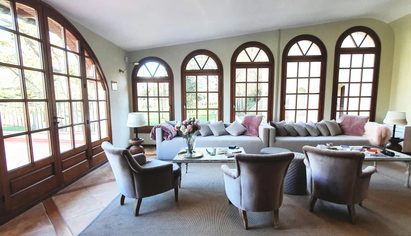 a living room filled with couches and windows