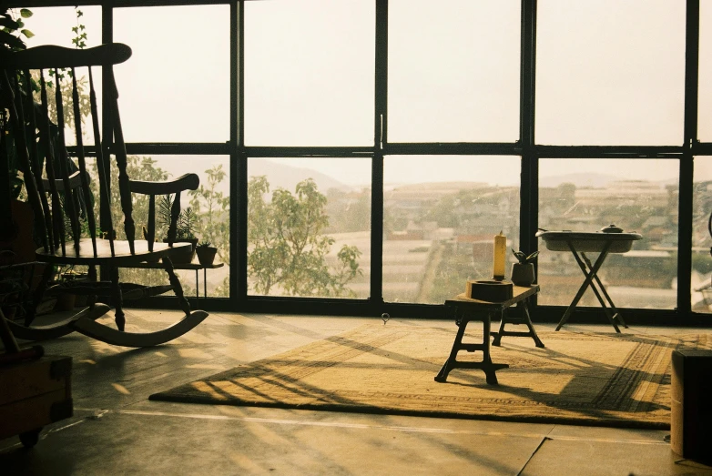 a rocking chair sits in a screened window, overlooking the countryside