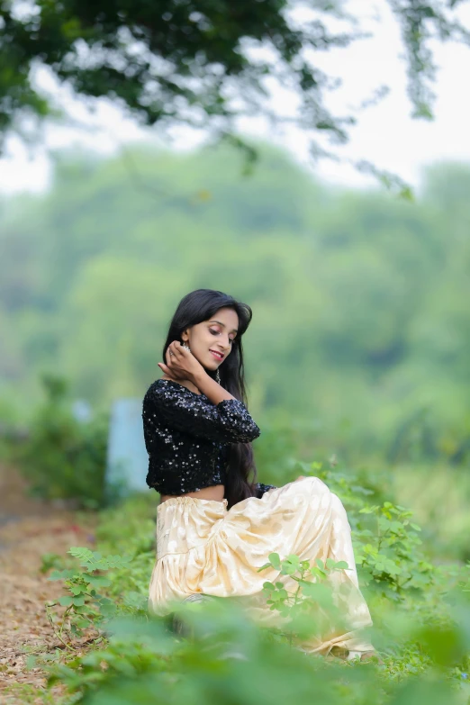 a girl with a black jacket on is standing in tall grass