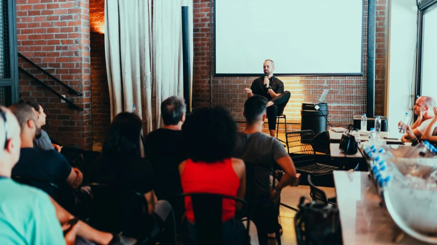 there is a man standing at a microphone in front of people