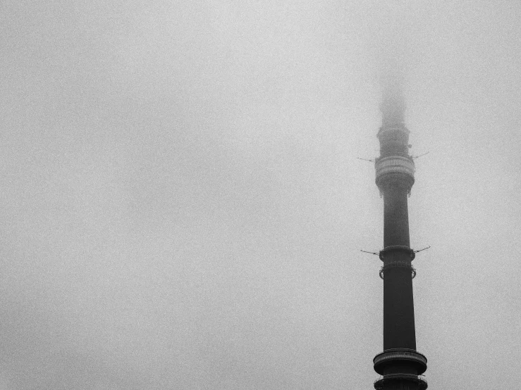 a black and white po of a clock tower with fog