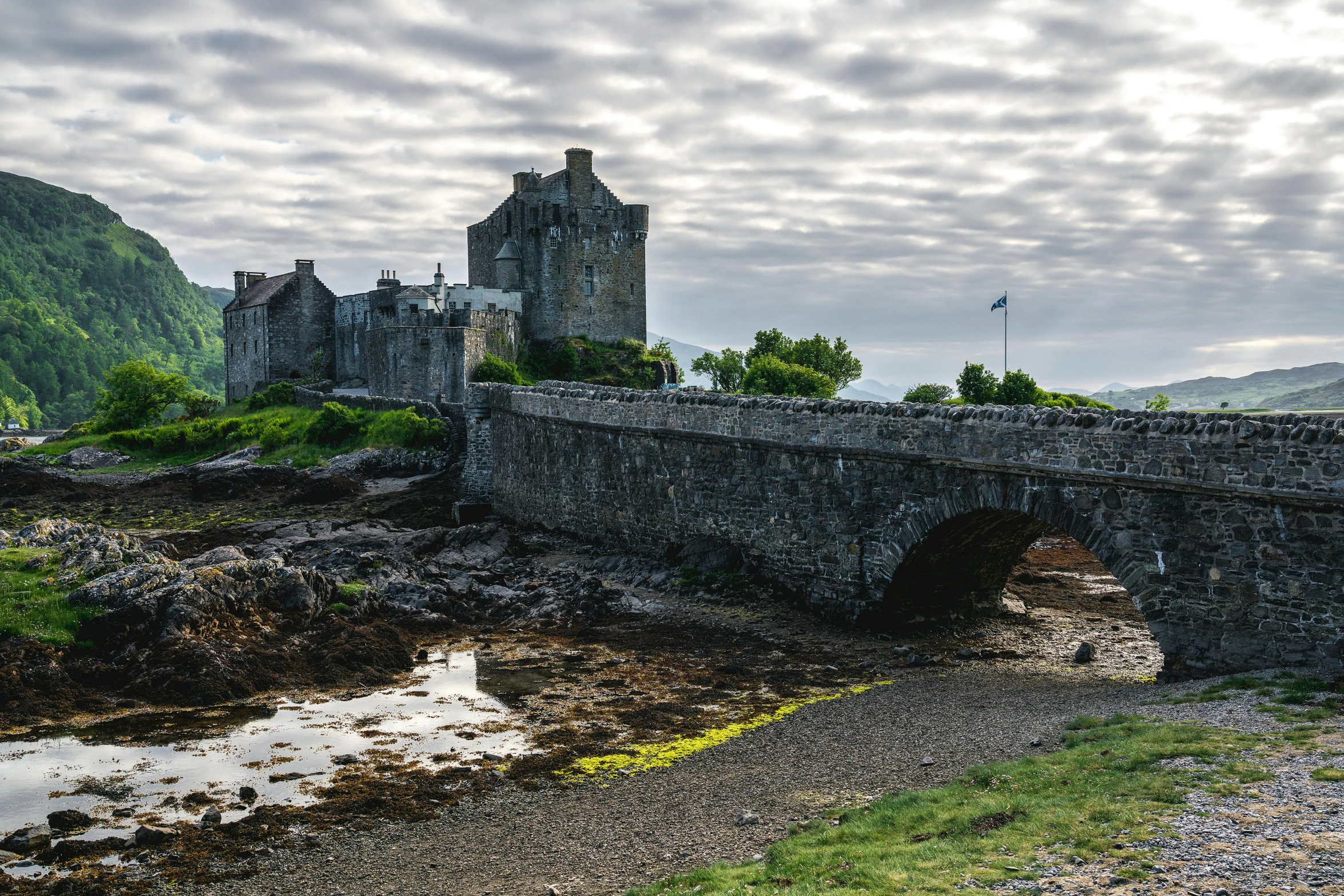 a stone bridge with a castle on top next to it