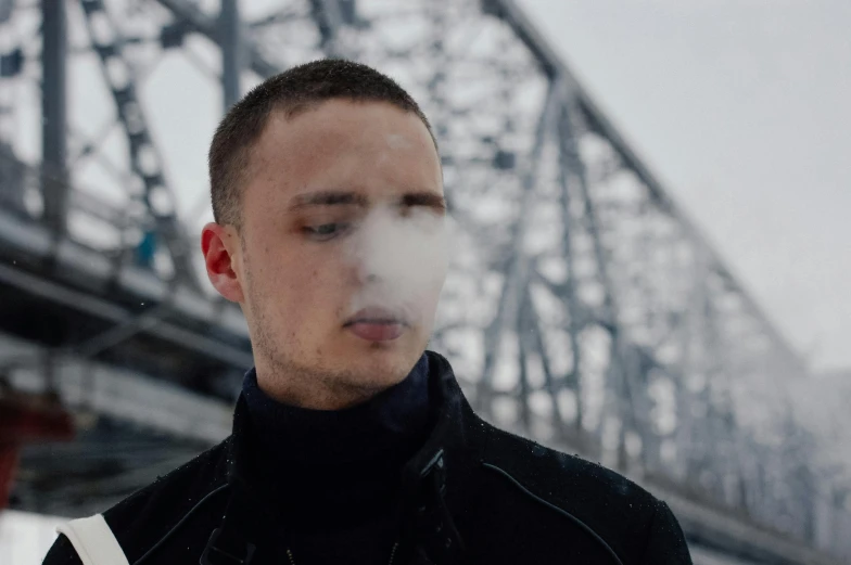 a man smokes while looking down on his phone