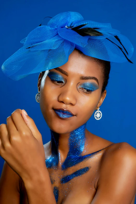 a woman in blue makeup is shown wearing a hat