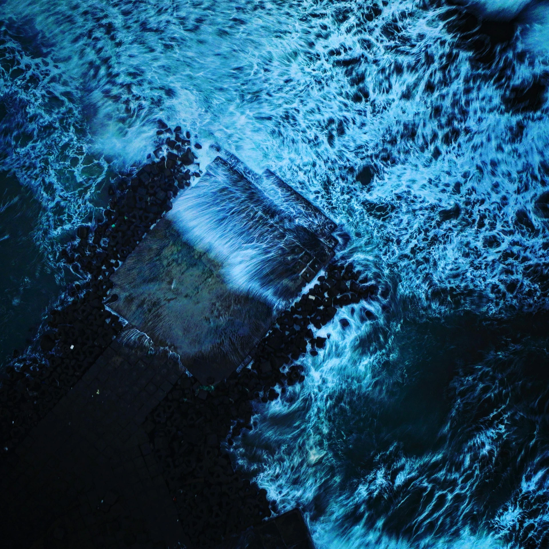 a piece of concrete sitting on top of blue water