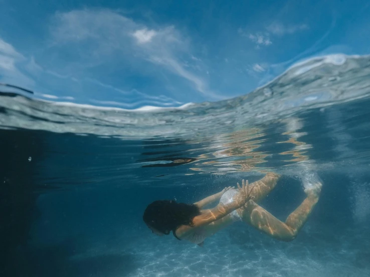 woman is in the ocean on her stomach under water