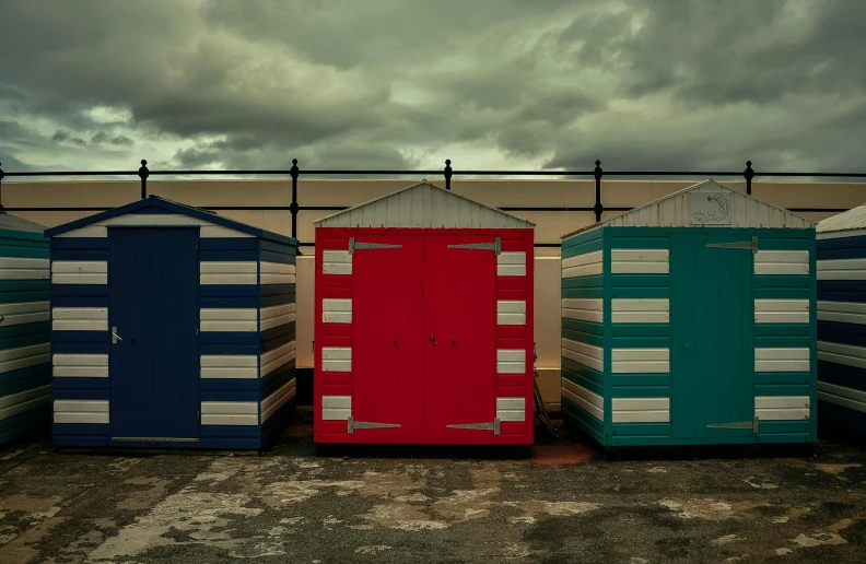 some very colorful beach huts with an overcast sky