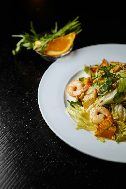 a plate of food with shrimp and green cabbage