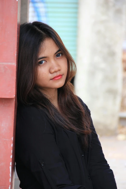 an attractive young lady leaning against the wall