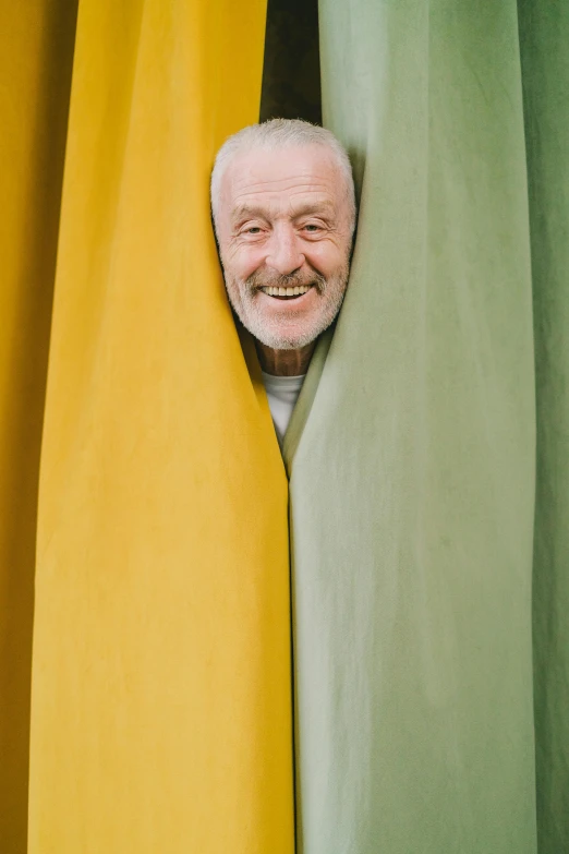 the man is peeking out from behind a curtain