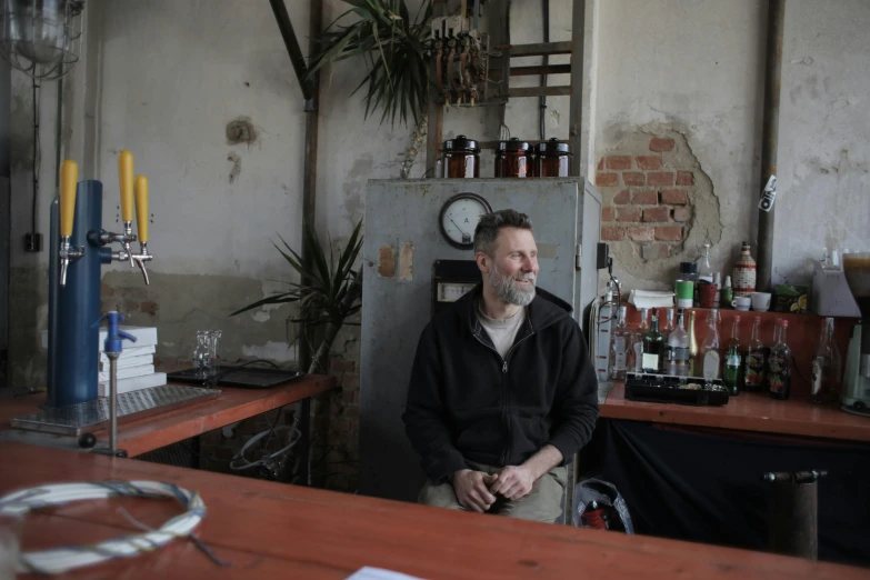 an older man sitting in front of a refrigerator