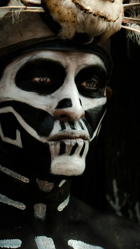 the face painted in white, black and grey is visible