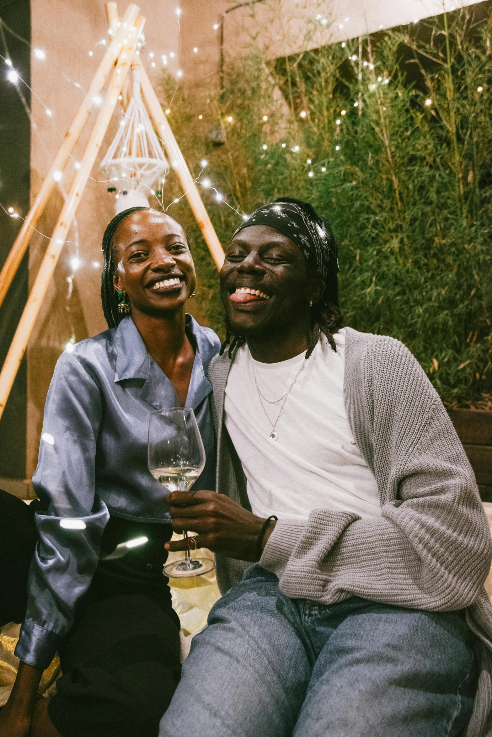 two men posing for a picture holding a wine glass