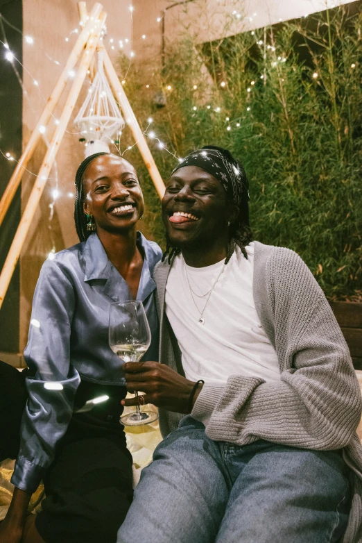 two men posing for a picture holding a wine glass