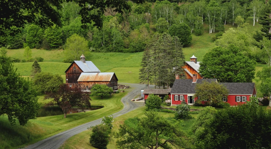 a red and white farm with trees, roads and small houses