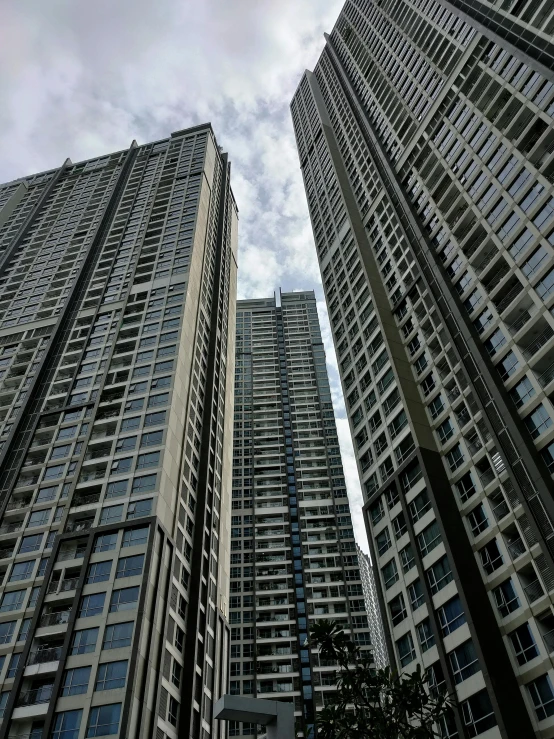 two large skyscrs stand against a cloudy sky